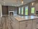 Bright living room featuring fireplace, mantel, three large windows and an open concept view to the kitchen at 105 Windchime Ct, Fuquay Varina, NC 27526