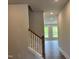 Hallway with wood-look flooring that has a staircase with painted risers and a stained railing at 105 Windchime Ct, Fuquay Varina, NC 27526