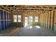 A bright, unfinished room featuring stud-framing, future window views, and open access to the outdoors at 3852 Well Fleet Drive, Willow Springs, NC 27592