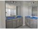 A bathroom featuring double vanities with grey cabinets and large mirrors in an unfinished space at 3856 Well Fleet Drive, Fuquay Varina, NC 27526