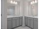 Double vanity bathroom with gray cabinets, quartz countertop and large mirrors at 3856 Well Fleet Drive, Fuquay Varina, NC 27526