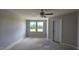 An empty bedroom space featuring a ceiling fan, natural light, and neutral paint at 3856 Well Fleet Drive, Fuquay Varina, NC 27526
