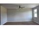 An empty bedroom with a ceiling fan, large window, and neutral paint at 3856 Well Fleet Drive, Fuquay Varina, NC 27526