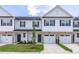 Charming townhome with a well-maintained lawn, a stone facade, and an attached garage at 3856 Well Fleet Drive, Fuquay Varina, NC 27526