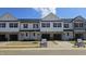 A modern townhouse exterior with a stone base and white siding under a blue sky at 3856 Well Fleet Drive, Fuquay Varina, NC 27526