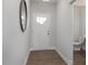 Hallway with wood-look flooring, leading to a powder room and the home's entry door at 3856 Well Fleet Drive, Fuquay Varina, NC 27526