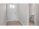 Hallway with wood-look flooring, leading to a powder room and the home's entry door at 3856 Well Fleet Drive, Fuquay Varina, NC 27526