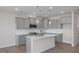 Well-lit kitchen with gray cabinets, stainless steel appliances, white countertops, and pendant lighting at 3856 Well Fleet Drive, Fuquay Varina, NC 27526