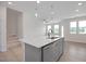 Bright, open-concept living space with kitchen island, stainless steel appliances, and views of the living room at 3856 Well Fleet Drive, Fuquay Varina, NC 27526