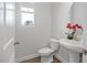 This half bathroom features a pedestal sink, wood-look floors, and a window at 3856 Well Fleet Drive, Fuquay Varina, NC 27526