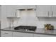Elegant kitchen with a modern cooktop, white subway tile backsplash, and plenty of counter space at 3856 Well Fleet Drive, Fuquay Varina, NC 27526