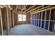 Partially constructed bedroom with visible framing, electric wiring, and window view to the outside at 3858 Well Fleet Drive, Willow Springs, NC 27592