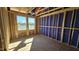 Bright bedroom under construction with exposed framing, large windows, and unfinished plywood flooring at 3858 Well Fleet Drive, Willow Springs, NC 27592