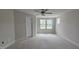 Spacious bedroom features neutral walls, baseboard trim, a closet door, and three windows at 3928 Well Fleet Drive, Fuquay Varina, NC 27526