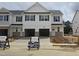 New construction townhome featuring stone accents, black shutters, and an attached two-car garage at 3928 Well Fleet Drive, Fuquay Varina, NC 27526