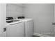This laundry room features a white washer and dryer set with wire shelving for storage at 3928 Well Fleet Drive, Fuquay Varina, NC 27526