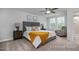 Sunlit bedroom features neutral tones, carpet, ceiling fan, ensuite bath, and sunny windows at 3930 Well Fleet Drive, Fuquay Varina, NC 27526