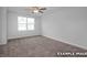Bright bedroom featuring plush carpeting, ceiling fan, and a large window for ample natural light at 3932 Well Fleet Drive, Fuquay Varina, NC 27526