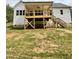 View of wooden backyard deck with stairs and overhead fan looking out over the yard at 40 Moonraker Dr, Spring Hope, NC 27882