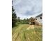 Sloping backyard view with a wooden deck and stairs attached to a white home at 40 Moonraker Dr, Spring Hope, NC 27882
