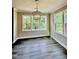 Dining room features dark hardwood-style floors and multiple windows overlooking a wooded area at 40 Moonraker Dr, Spring Hope, NC 27882