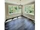 A sun-drenched dining room with a modern chandelier and luxury vinyl plank floors at 40 Moonraker Dr, Spring Hope, NC 27882