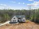 New construction home with a modern farmhouse exterior, set against a backdrop of trees at 40 Moonraker Dr, Spring Hope, NC 27882