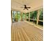 Inviting screened porch with wood flooring, ceiling fan, and black railings, surrounded by lush greenery at 40 Moonraker Dr, Spring Hope, NC 27882