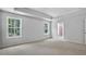 Bedroom featuring soft carpet, two windows, and a tray ceiling at 7537 Percussion Dr, Apex, NC 27539