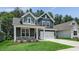 Charming two-story home featuring a two-car garage, gray siding, stone accents, and a well-manicured lawn at 7537 Percussion Dr, Apex, NC 27539
