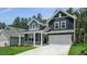 Charming two-story home featuring a two-car garage, gray siding, stone accents, and a well-manicured lawn at 7537 Percussion Dr, Apex, NC 27539