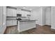A well-equipped kitchen features white cabinets, stainless steel appliances, and an island at 7537 Percussion Dr, Apex, NC 27539