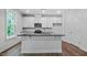 Modern kitchen with white cabinets, stainless steel appliances, and a central island at 7537 Percussion Dr, Apex, NC 27539