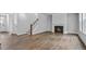 Open-concept living room with a fireplace, wood floors, and natural light at 7537 Percussion Dr, Apex, NC 27539