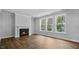 Bright living room featuring wood floors, a fireplace, and large windows at 7537 Percussion Dr, Apex, NC 27539