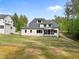 Spacious backyard featuring lush green grass, mature trees, and the rear of a white house with a screened-in porch at 7813 Ailesbury Rd, Wake Forest, NC 27587