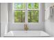 Spa-like bathroom with a luxurious soaking tub and a serene view of the woods at 7813 Ailesbury Rd, Wake Forest, NC 27587