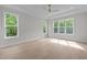 Light-filled bedroom with hardwood floors and large windows overlooking lush greenery at 7813 Ailesbury Rd, Wake Forest, NC 27587