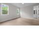 Bright bedroom features wood floors, neutral walls, two windows, and an ensuite bathroom at 7813 Ailesbury Rd, Wake Forest, NC 27587