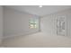 Spacious bedroom with a large window and neutral carpet flooring at 7813 Ailesbury Rd, Wake Forest, NC 27587