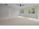 Large bedroom with neutral carpeting, two windows, and modern ceiling fan at 7813 Ailesbury Rd, Wake Forest, NC 27587