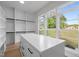 Walk-in closet with lots of natural light, custom shelving, drawers, and a center island at 7813 Ailesbury Rd, Wake Forest, NC 27587