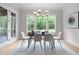 Bright dining room with natural light, stylish chandelier, and views of the wooded outdoors at 7813 Ailesbury Rd, Wake Forest, NC 27587