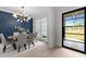 An elegant dining room featuring a modern chandelier, stylish chairs, and a blue accent wall at 7813 Ailesbury Rd, Wake Forest, NC 27587