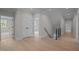 Bright hallway features hardwood floors, white walls, a staircase and natural light at 7813 Ailesbury Rd, Wake Forest, NC 27587