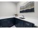 Functional laundry room with stylish blue cabinets, white countertops, and modern hardware for organization at 7813 Ailesbury Rd, Wake Forest, NC 27587