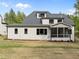 View of the rear exterior featuring a grey roof, white siding, and a screened-in porch with a brick foundation at 7813 Ailesbury Rd, Wake Forest, NC 27587