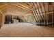 Spacious unfinished attic space with exposed wood framing, plywood flooring, and natural light from a window at 7813 Ailesbury Rd, Wake Forest, NC 27587
