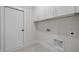A neatly finished utility room featuring white cabinetry, trim, and tile flooring for a clean aesthetic at 7813 Ailesbury Rd, Wake Forest, NC 27587