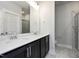 Bathroom with double vanity, a large mirror, and a tiled shower with a glass door at 85 Windchime Ct, Fuquay Varina, NC 27526